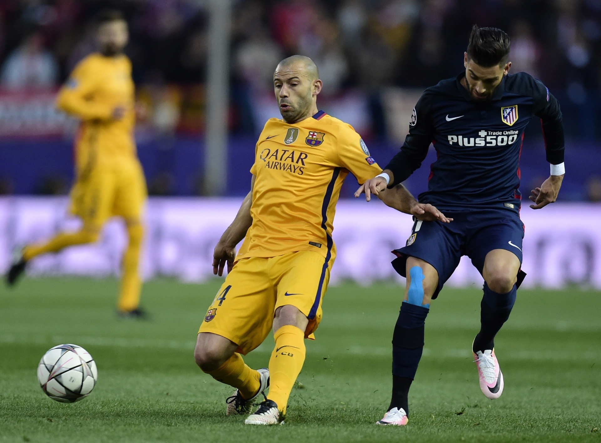 Mascherano e Ferreira Carrasco disputam bola na partida entre Atlético de Madri e Barcelona pela Liga dos Campeões - Javier Soriano/AFP Photo