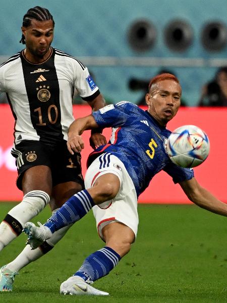 Nagatomo, do Japão, disputa com Serge Gnabry, da Alemanha, em partida na Copa do Mundo de 2022 - INA FASSBENDER / AFP