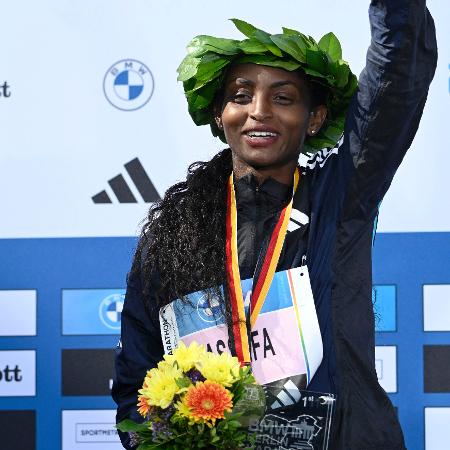 Assefa comemora no pódio após vencer em Berlim e fazer o novo recorde mundial