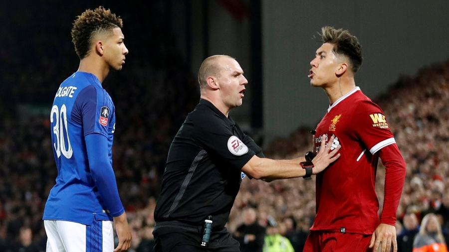 O árbitro  Bobby Madley segura o brasileiro Roberto Firmino, do Liverpool, durante jogo do Campeonato Inglês - Reuters/Carl Recine