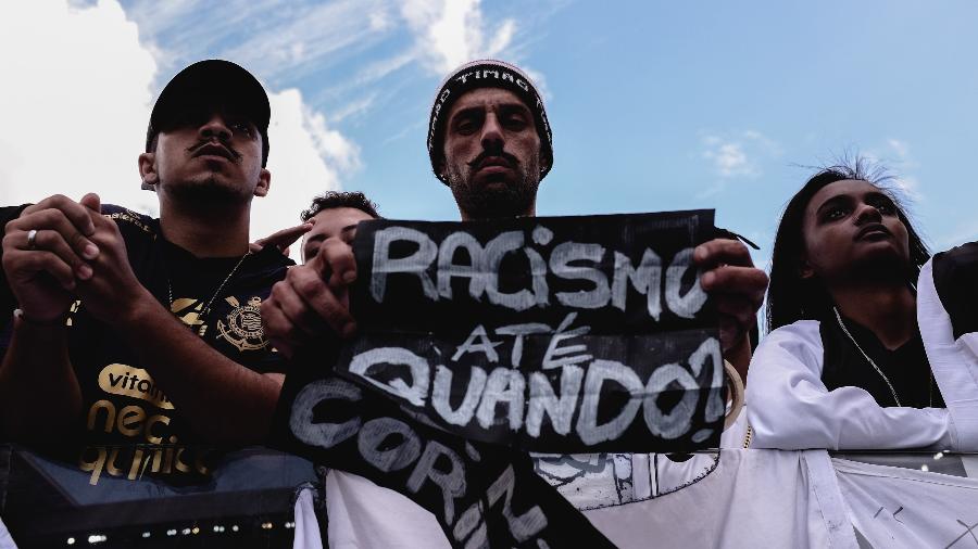 Torcedor do Corinthians com faixa "Racismo até quando?" durante partida entre Corinthians e Fortaleza na Neo Química Arena - Ettore Chiereguini/AGIF