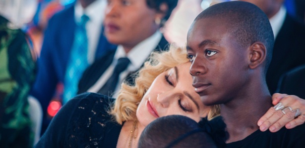 Madonna deita no ombro de seu filho David Banda durante evento em Malawi - Amos Gumulira/AFP