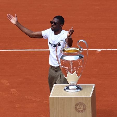 Dembélé, atacante do PSG e craque da Liga dos Campeões, levou a taça da competição até a quadra central de Roland Garros Dembélé, atacante do PSG e craque da Liga dos Campeões, levou a taça da competição até a quadra central de Roland Garros