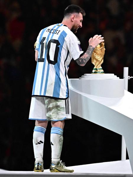 Messi faz carinho na taça da Copa do Mundo depois de Argentina ser tri mundial - Anne-Christine POUJOULAT / AFP