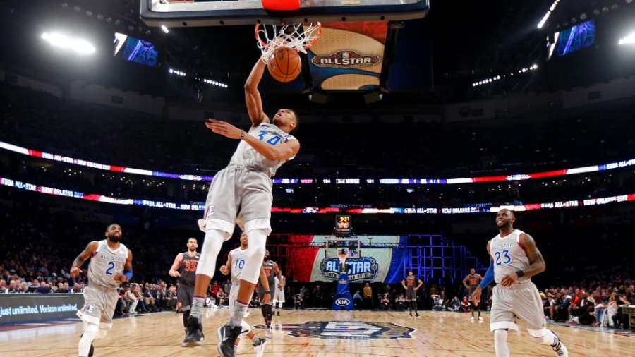 Antetokounmpo enterra uma bola no Jogo das Estrelas de 2017 enquanto Curry deita na quadra - Larry W. Smith/Pool Photo-USA TODAY