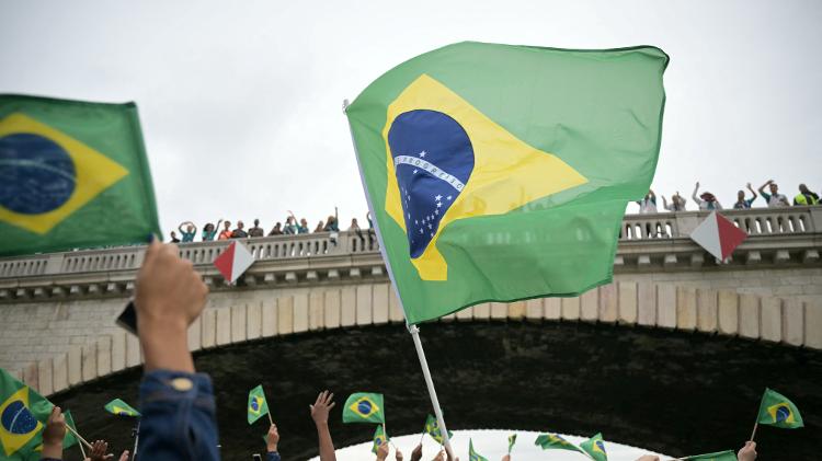 Bandeiras são erguidas pela delegação de atletas brasileiros durante cerimônia de abertura das Olimpíadas