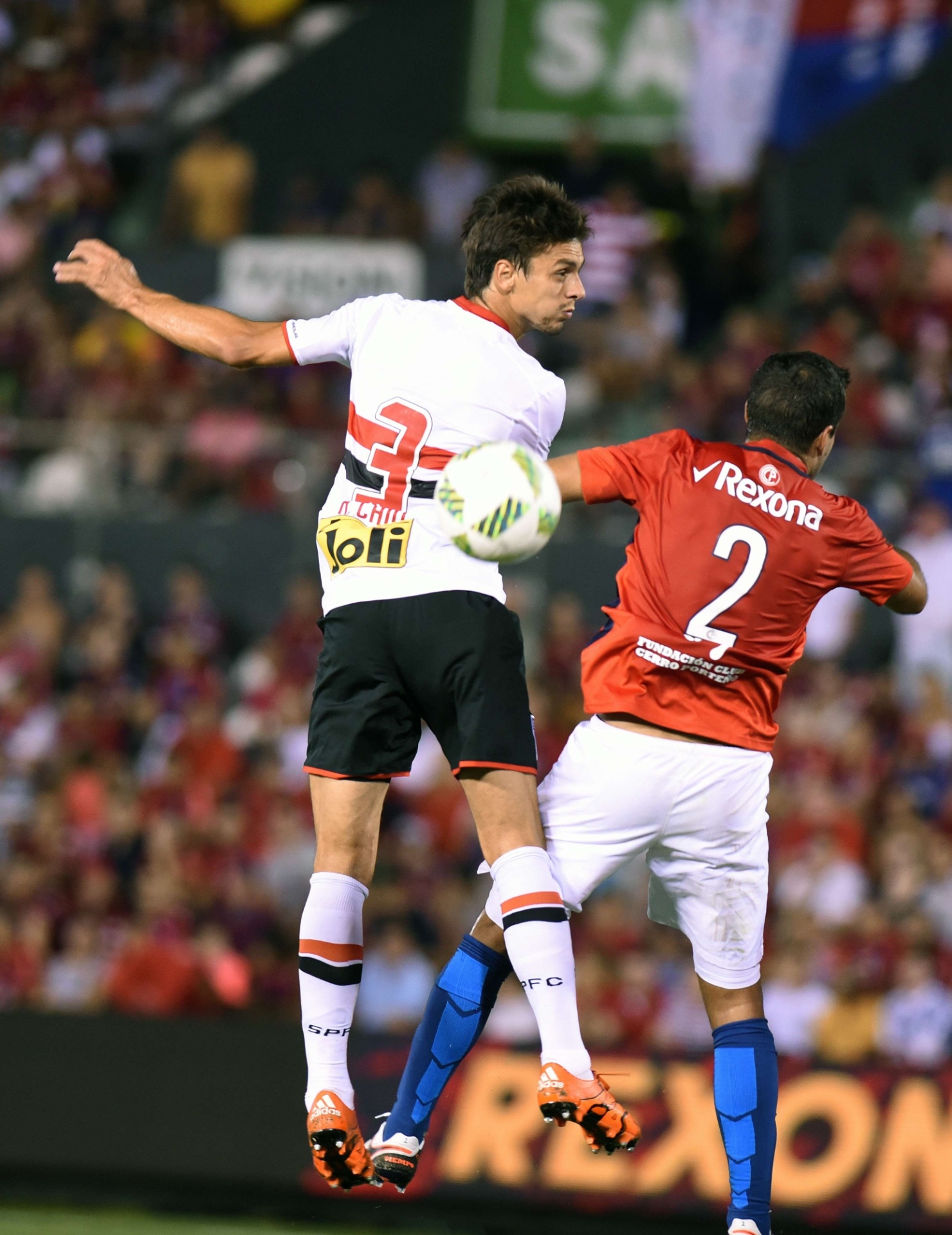 Rodrigo Caio e Raul Caceres disputam bola por cima no jogo do São Paulo contra o Cerro Porteño - AFP PHOTO / NORBERTO DUARTE