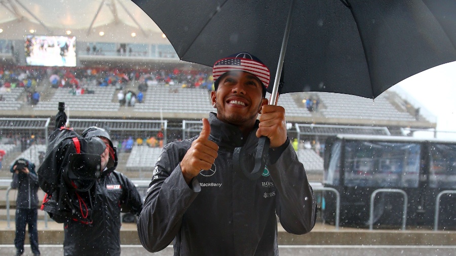 Lewis Hamilton, líder absoluto da Fórmula 1 em 2015, acena para os fotógrafos cheio de estilo no paddock do GP dos EUA, que foi bastante afetado pelo mau tempo em Austin, no Texas.  - Mark Thompson/Getty Images/AFP