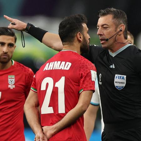 Árbitro brasileiro Raphael Claus repreende Ahmad, do Irã, na partida contra a Inglaterra pela Copa do Mundo - Adrian DENNIS / AFP