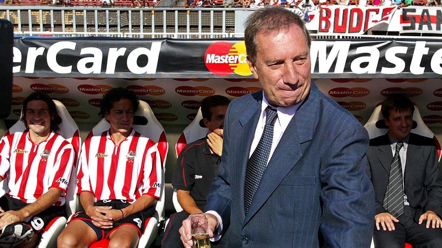 Carlos Bilardo finge beber champanhe em jogo do Estudiantes contra o River Plate, em 2004. Histórias do treinador viraram série - AFP: France Presse