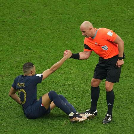 Árbitro Szymon Marciniak ajuda Mbappé a se levantar durante final da Copa do Mundo do Qatar - Xinhua/Pan Yulong