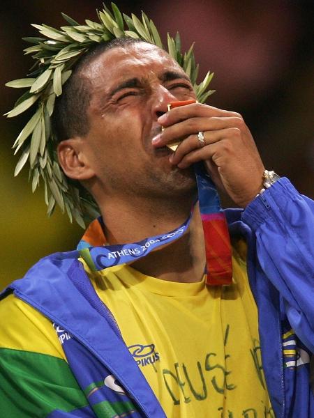 Sérgio Escadinha, líbero da seleção brasileira de vôlei, beija a medalha de ouro conquista nas Olimpíadas de Atenas, em 2004 - Adam Pretty/Getty Images