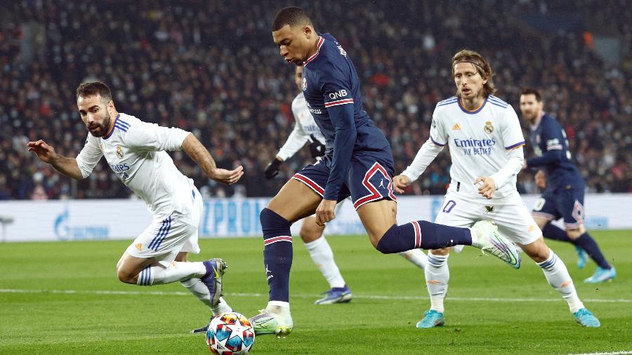 Kylian Mbappé encara marcação dupla de Carvajal e Modric durante PSG x Real Madrid na Champions - REUTERS/Gonzalo Fuentes