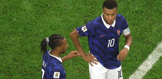 French players celebrating a late goal with a determined expression on their faces during a dramatic World Cup match.