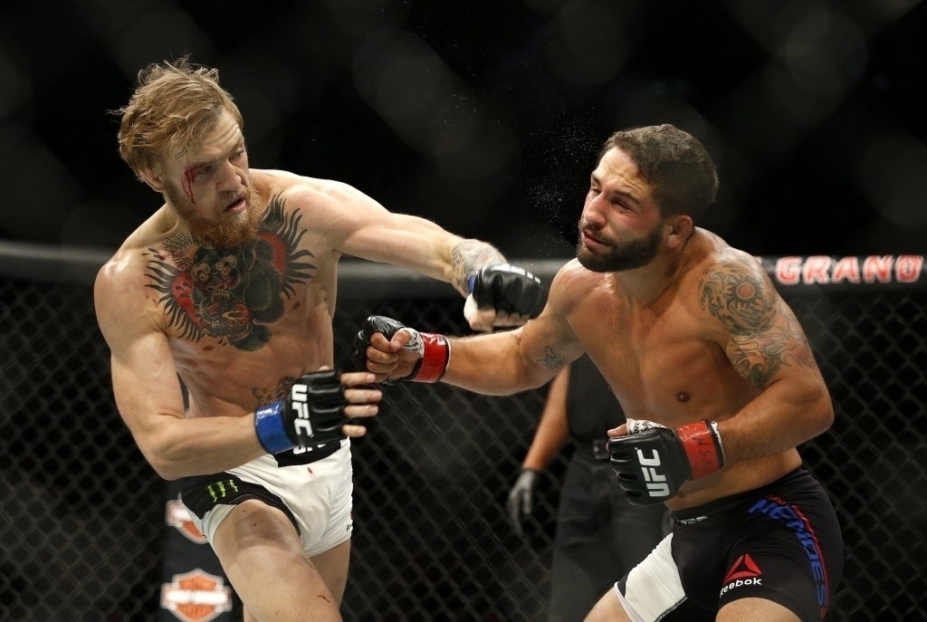 Conor McGregor acerta soco no rosto de Chad Mendes, na luta principal do UFC 189; McGregor venceu a luta por nocaute técnico e se tornou o campeão interino dos penas - John Locher/AP Photo