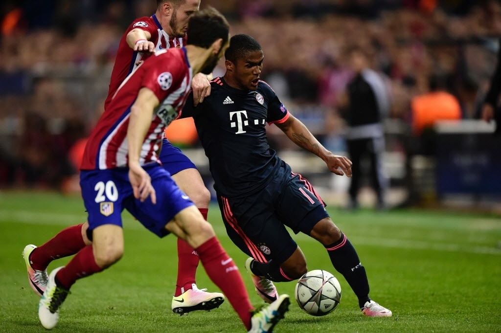 Douglas Costa, meia-atacante brasileiro do Bayern de Munique, parte para cima da marcação do Atlético de Madri durante semifinal da Liga dos Campeões da Europa - AFP PHOTO / JAVIER SORIANO
