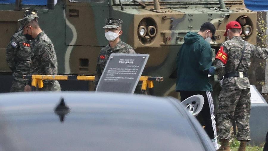 O jogador Son Heung-min, de calça preta, passará três semanas no serviço militar sul-coreano - YONHAP/AFP/Getty Images