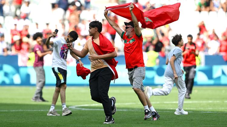 IMAGEM DO DIA: Torcedores do Marrocos invedem o campo no jogo de futebol contra a Argentina