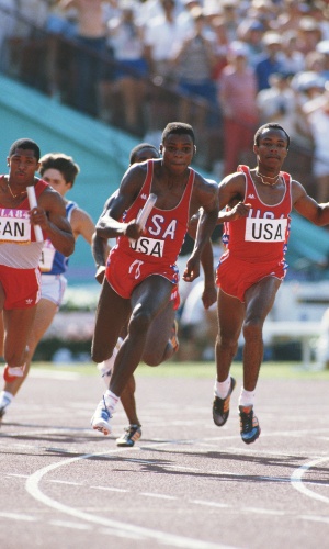 11.ago.1984 - Carl Lewis pega o bastão e finaliza o revezamento dos Estados Unidos para vencer o 4 x 100 m na Olimpíada de Los Angeles-1984
