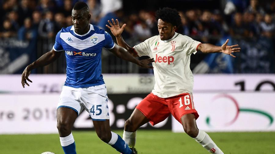 Mario Balotelli, do Brescia, disputa bola com Juan Cuadrado, da Juventus, pelo Campeonato Italiano - Marco Bertorello / AFP