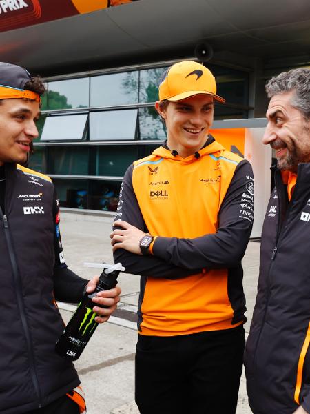 Os pilotos da McLaren Lando Norris (esq) e Oscar Piastri (centro) com o chefe Andrea Stella