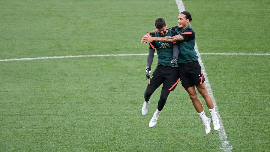 Alisson e Van Dijk brincam em treino de reconhecimento do Liverpool no gramado do Stade de France, palco da final da Champions - JAVIER SORIANO / AFP