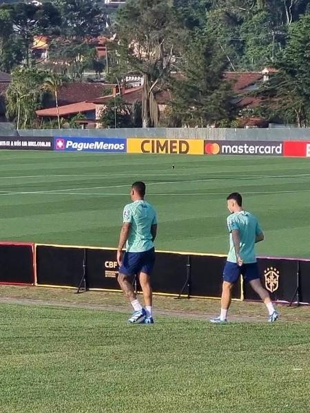 Gabriel Jesus e Martinelli caminham para o campo no treino da seleção