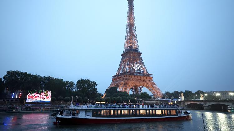 Vista de um barco no Rio Sena com a Torre Eiffel ao fundo durante cerimônia de abertura das Olimpíadas