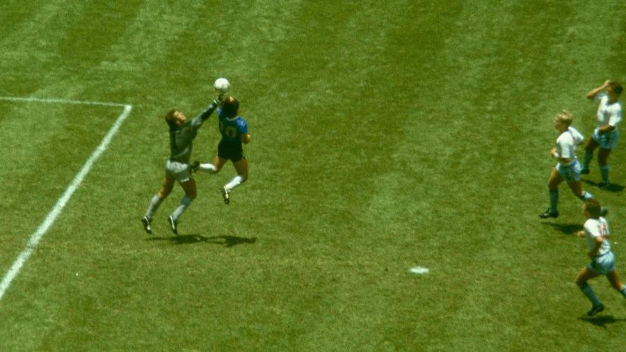 Diego Maradona em disputa de bola com o goleiro da Inglaterra Peter Shilton para marcar de mão, na Copa do Mundo de 1986 - gol "A mão de Deus"