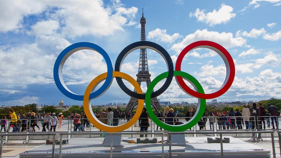Anéis olímpicos na frente da Torre Eiffel, em Paris; Olimpíadas começam em julho