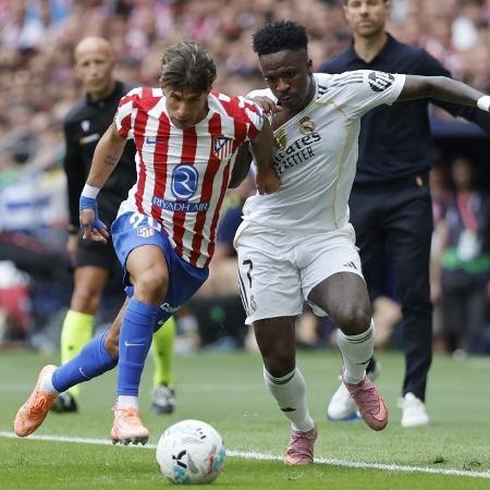 Vini Jr. e Giuliano Simeone disputam lance no clássico entre Atlético e Real Madrid