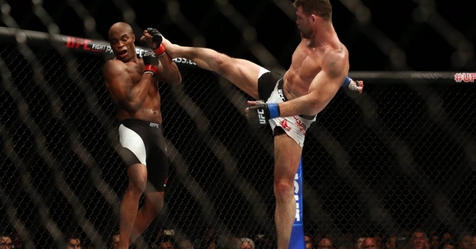 Anderson Silva tenta se defender de chute alto de Michael Bisping, na luta principal do UFC em Londres, neste sábado (27)