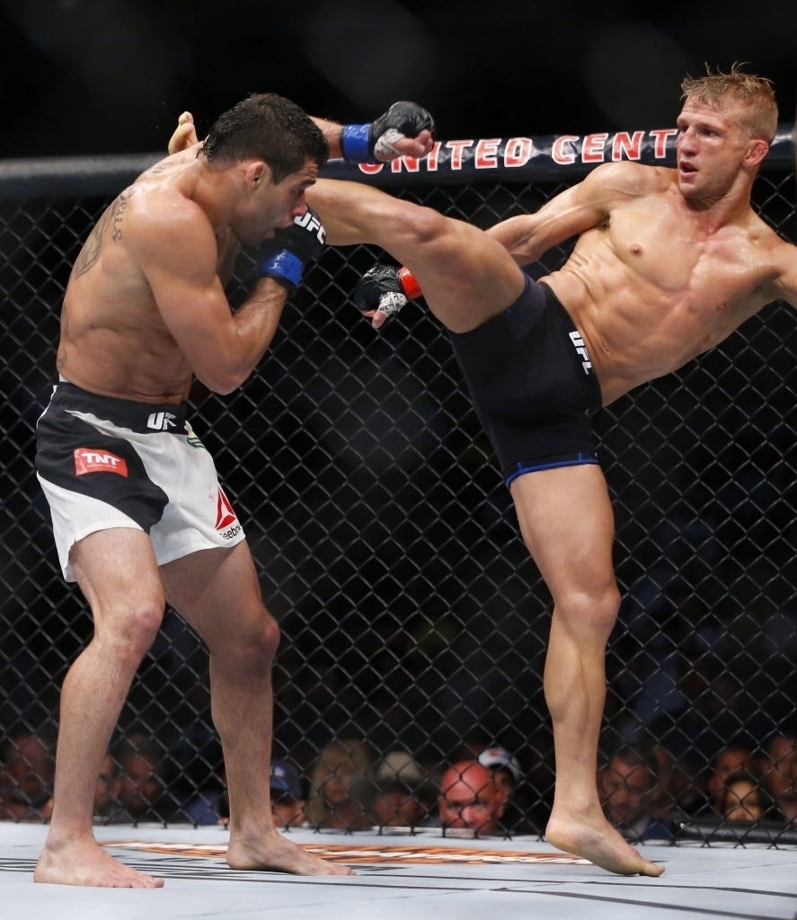 TJ Dillashaw (dir.) acerta chute alto em Renan Barão; Dillashaw venceu por nocaute técnico e manteve o cinturão dos galos após o combate deste sábado (25), em Chicago, nos Estados Unidos - Jeff Bottari/Zuffa LLC UFC