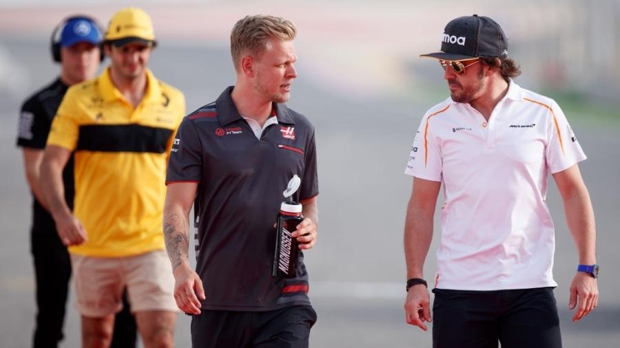 Kevin Magnussen (esq) conversa com Fernando Alonso  - Lars Baron/Getty Images
