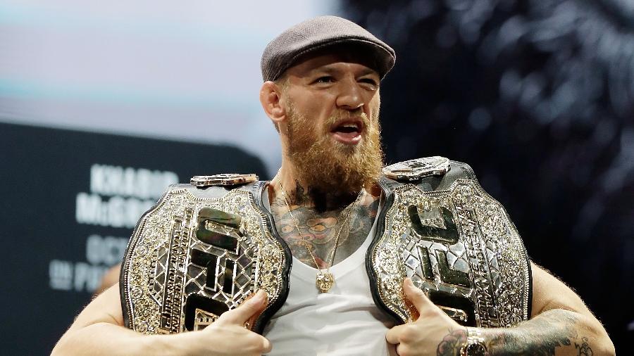 Conor McGregor ergue dois cinturões do UFC - Isaac Brekken/Getty Images
