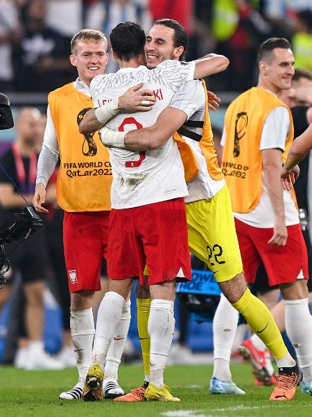 Kamil Grabara, goleiro reserva da Polônia, abraça Robert Lewandowski após classificação para a próxima fase da Copa - BSR Agency/Getty Images