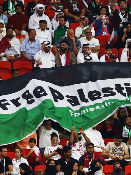 Torcedores dentro do estádio Al Bayt seguram uma bandeira com a mensagem "Palestina Livre" - REUTERS/Bernadett Szabo