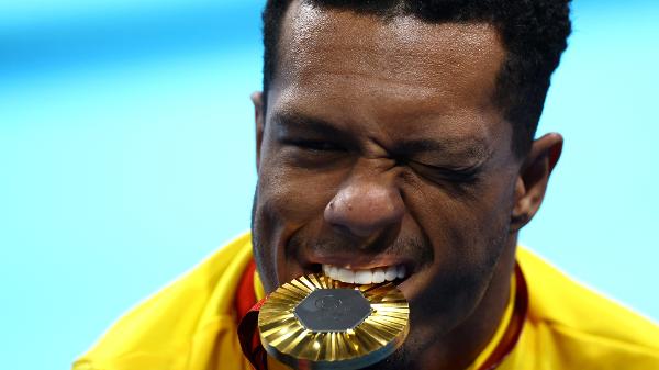 Gabrielzinho morde a medalha de ouro após conquistar o título dos 100m costas da classe S2