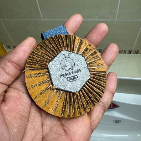 Yohann Ndoye Brouard, nadador francês, mostra medalha das Olimpíadas de Paris-2024 desbotada