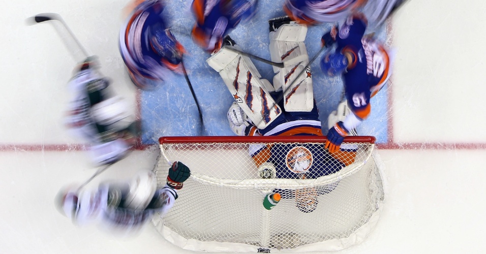 24.mar - Jaroslav Halak, goleiro do the New York Islanders, deita em cima do disco para evitar gol durante partida contra o Minnesota Wild, em Nova York