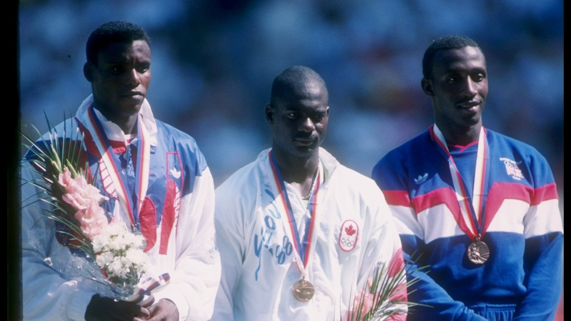 Carl Lewis (e), Ben Johnson (c) e Linford Christie recebem suas medalhas no pódio dos 100 m rasos da Olimpíada de Seul-1988