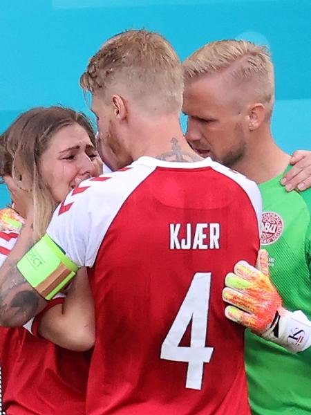 Goleiro da Dinamarca Kasper Schmeichel e zagueiro Simon Kjaer confortam Sabrina Kvist Jensen, namorada de Christian Eriksen - WOLFGANG RATTAY/AFP