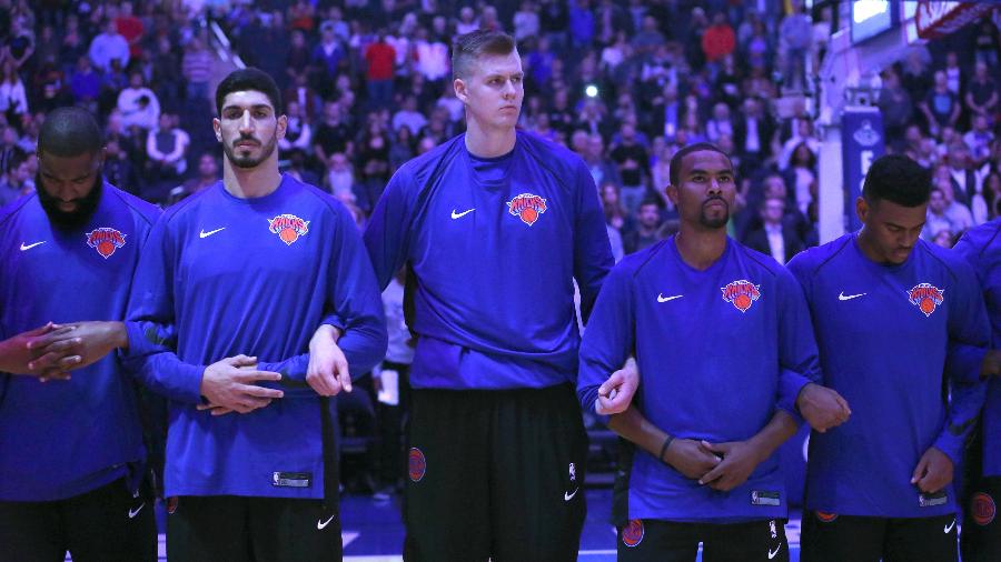 Kristaps Porzingis, Enes Kanter e demais jogadores dos Knicks cruzam braços durante execução do hino americano - Noah K. Murray/USA TODAY Sports