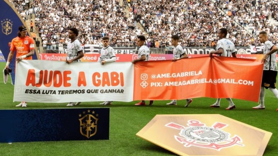 "Ajude a Gabi": jogadores do Corinthians entraram em campo no jogo contra o Santos com faixa em prol de bebê com AME - Reprodução/Twitter