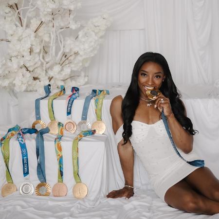 Simone Biles posa para foto com as 11 medalhas olímpicas da carreira