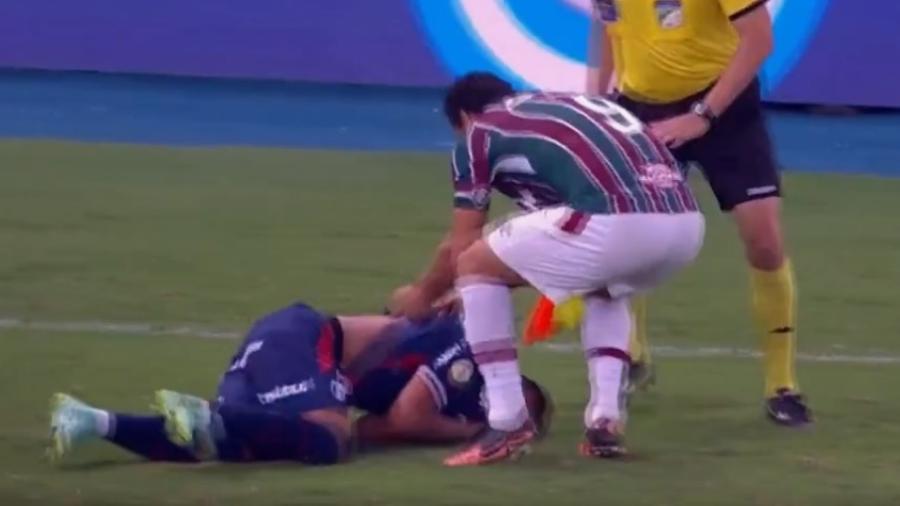 Após derrubar Ronald, atacante do Fluminense puxou o adversário pela camisa para tentar levantá-lo - Reprodução/Twitter