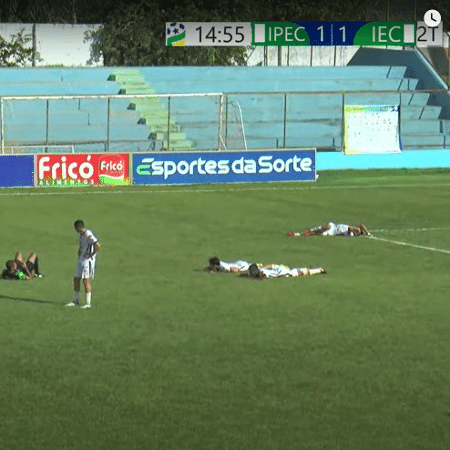 Atletas do Iporá e do Inhumas se deitaram no gramado para se proteger das ferroadas - Reprodução/FGVTV