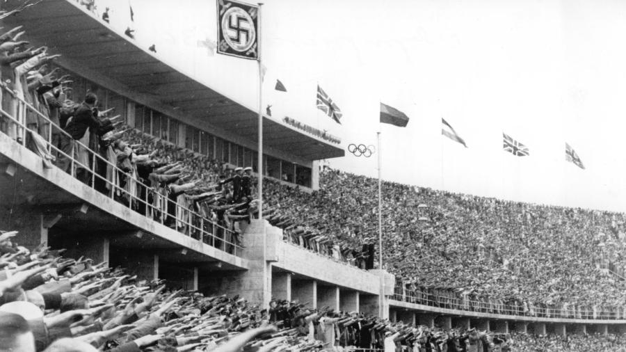 Pessoas presentes no Estádio Olímpico de Berlim fazem a saudação nazista durante a cerimônia de abertura dos Jogos Olímpicos de 1936 - Schirner Sportfoto/picture alliance via Getty Images