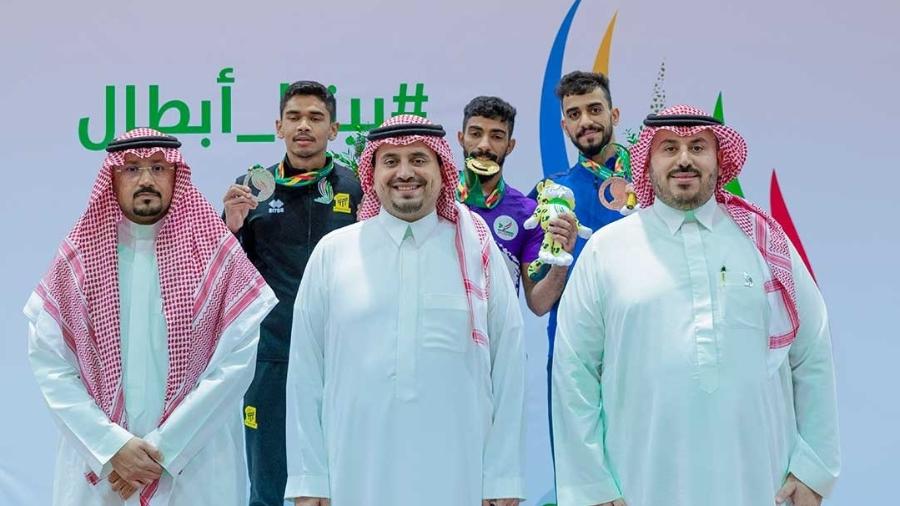 Dirigentes da Arábia Saudita com atletas no pódio da ginástica nos Saudi Games
