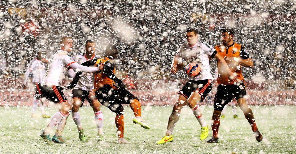 13.jan - Jogadores de Wolverhampton Wanderers e Fulham, em Wolverhampton (ING), disputam bola sob neve, em jogo da terceira fase da FA Cup